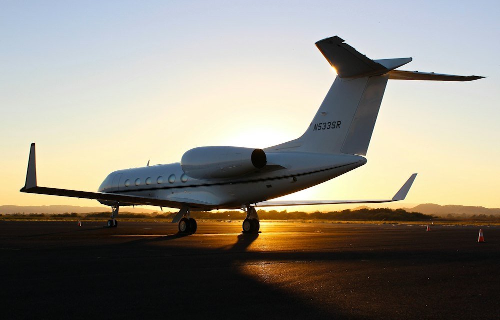White private jet on the airport tarmac at golden hour