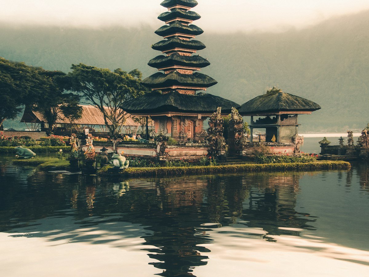 Multi-tiered Balinese temple reflected in a calm lake