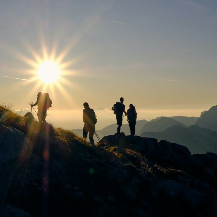 Four friends standing together on a mountain